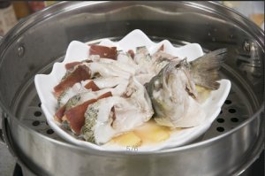 將鱸魚成花狀擺好，將火腿切片放入各縫隙中，放入鍋中隔水蒸12分鐘拿出，撒上蔥花即可。