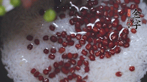 將炒好的食材和大米、紅豆一起放進(jìn)電飯鍋煮。