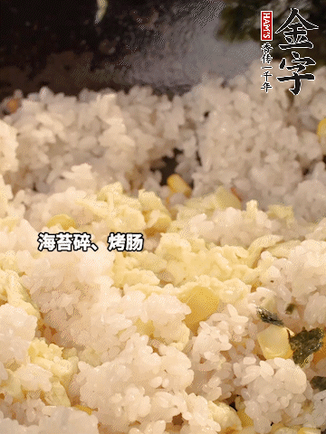 剩米飯下鍋炒散，依次下玉米粒、雞蛋、烤腸、海苔碎翻炒均勻。