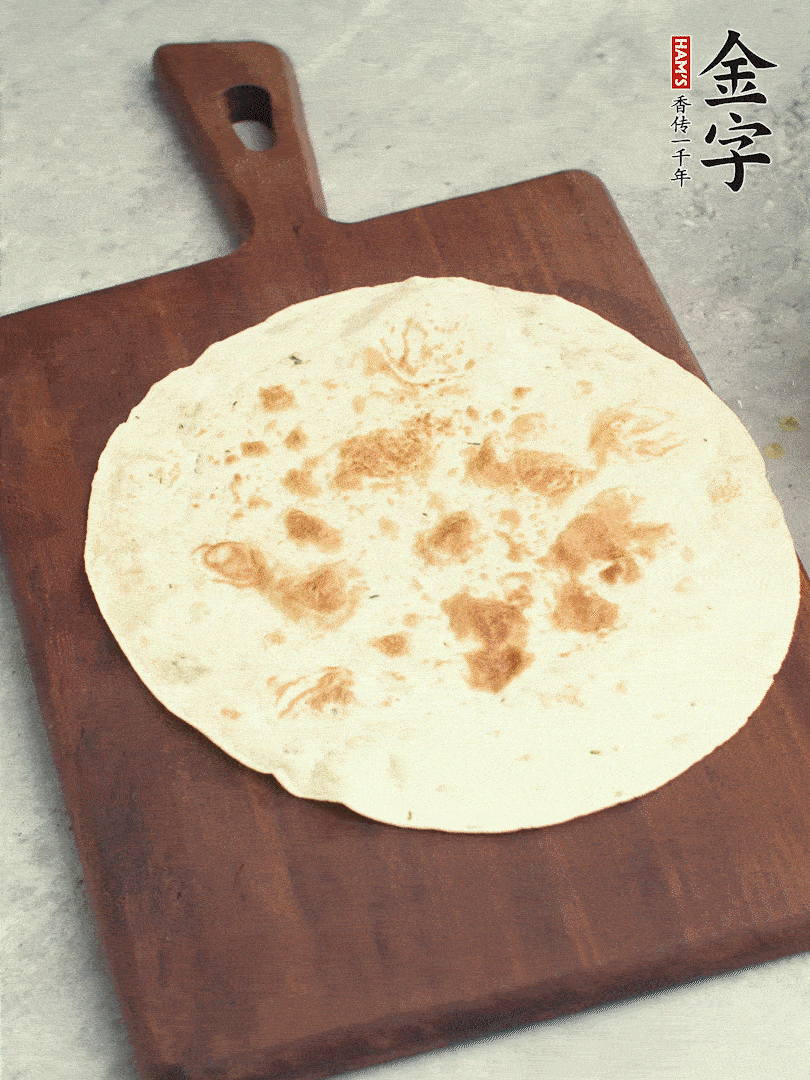 食材依次鋪在卷餅皮上，卷起來。