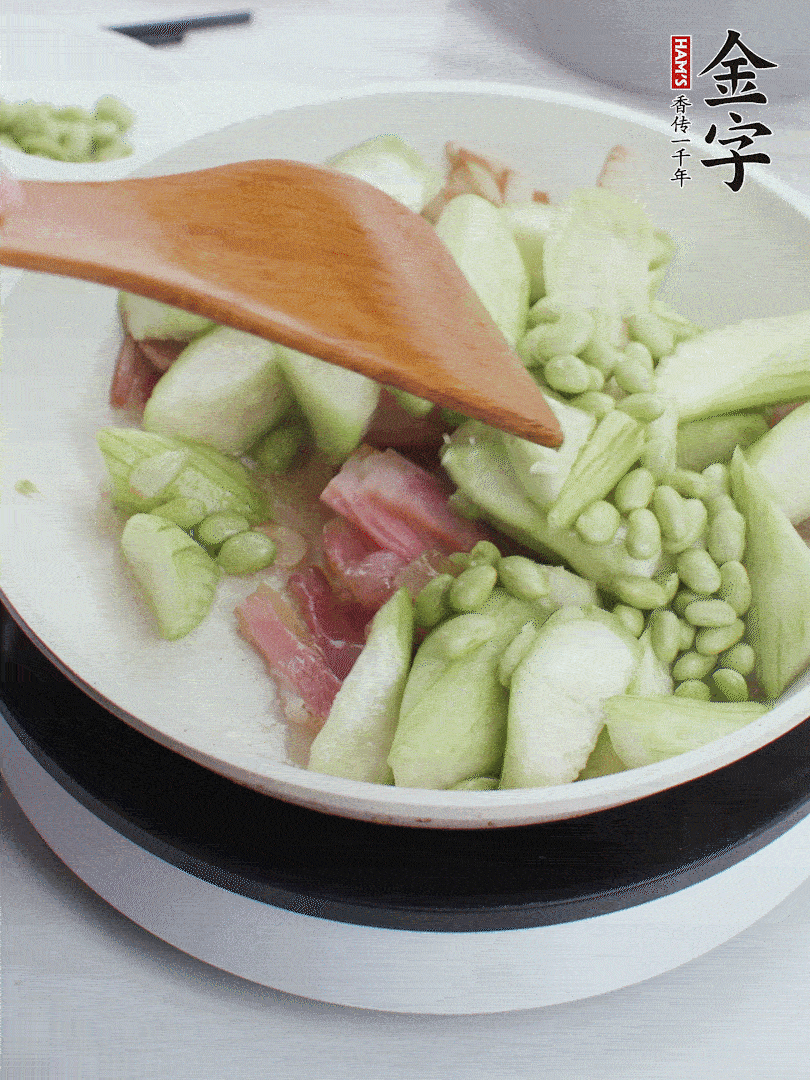 依次下絲瓜、青豆翻炒，炒至絲瓜打蔫縮小。