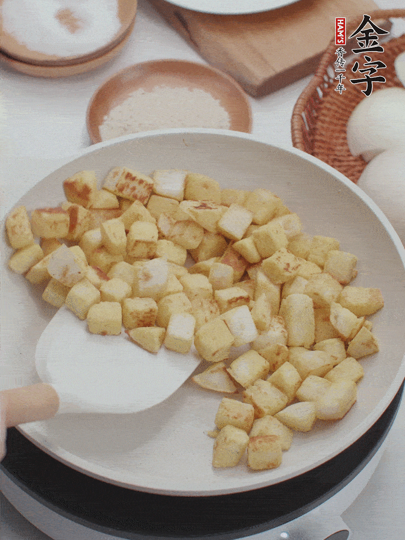 起鍋熱油，倒入饅頭丁，小火煎至蛋液凝固定型再翻面，饅頭丁部煎至金黃時盛起待用。