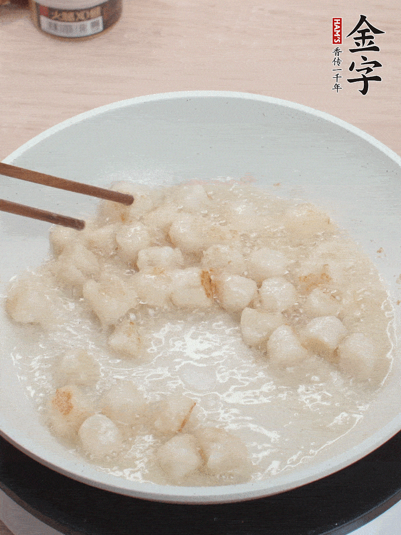 油溫4成熱，鮮貝蘸干淀粉下鍋煎，一面微黃后翻面。