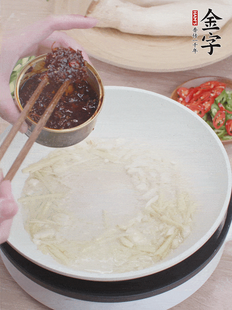 起鍋熱油，姜蒜、金字火腿干貝醬煸香。