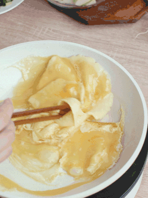 油6成熱時(shí)，下雞蛋液，邊緣凝固時(shí)翻拌成塊狀。