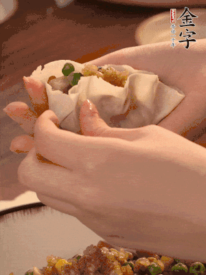 取一大勺餡料放進(jìn)餃子皮里，用大拇指按住頂部餡料，再用虎口掐出形狀。